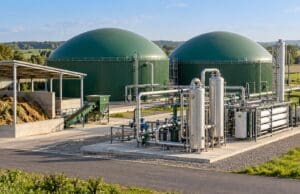 Biyometan üretim sürecini temsil eden yeşil kubbeli biyogaz reaktörleri, paslanmaz çelik gaz ayırma ekipmanı, membran modülleri ve bağlantı boruları