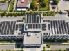 Bir binanın düz çatısındaki güneş panellerinin üstten görünümü; montaj sistemi haberi için temsili görsel.